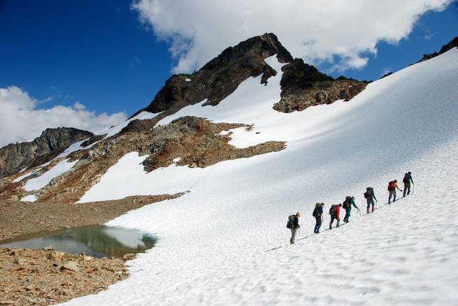 Students mountaineering on a snowy slope in the remote and rugged North Cascade Range.