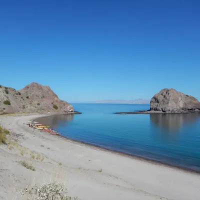 A large cove in Baja with a group of students gathering after a day out on the sea.