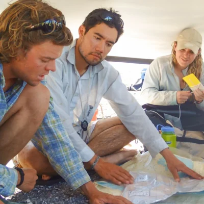 Students studying maps and planning routes during their navigation class at the Beatriz Anchorage, Mexico.