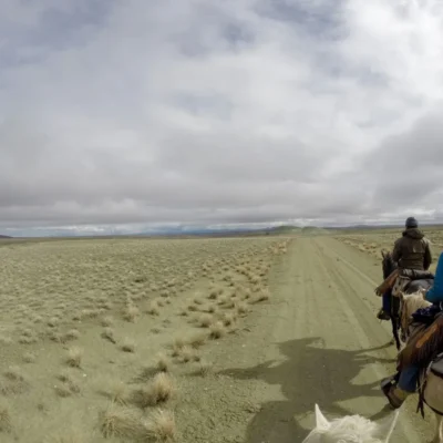 Students traveling on horses through a desert section of a horse-packing course.