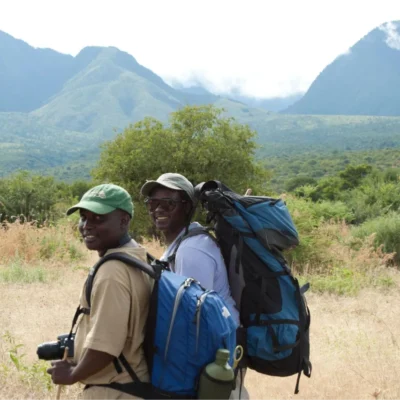 Students pause for a picture in Tanzania, with a vast mountain range behind them.