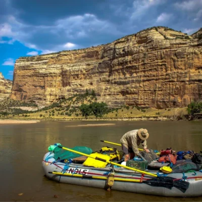 Great view facing an instructor on a pack raft, facing a canyon wall.