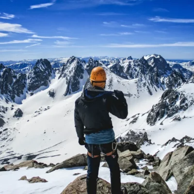 A student holding an ice ax gazing across the vast Wind River range.