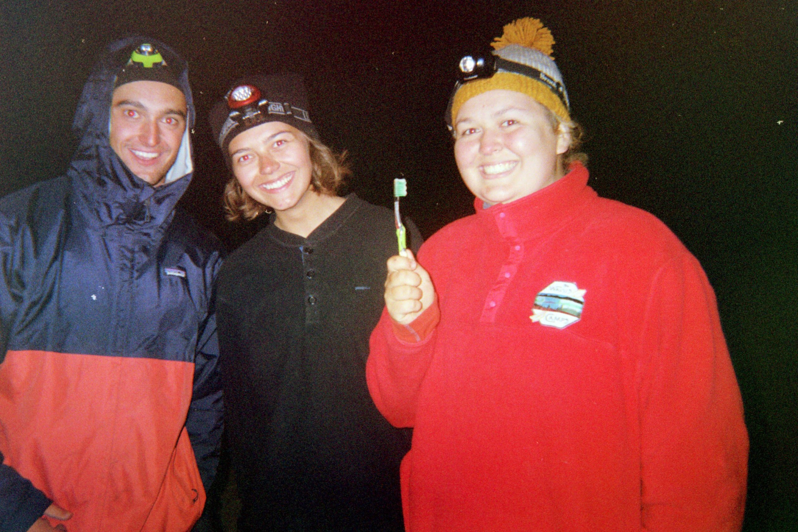 Students get ready for bed after dark with their headlamps