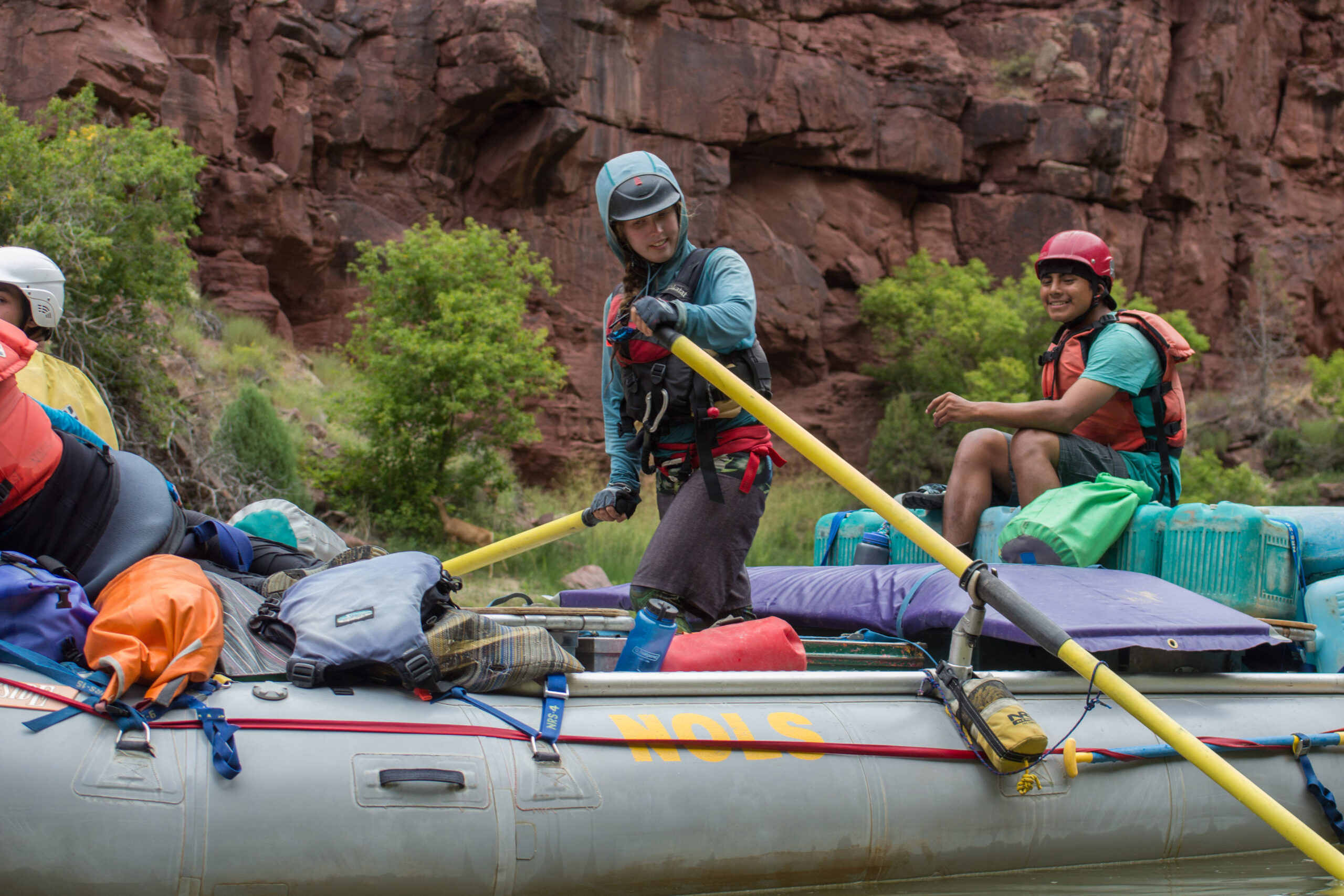 Students steer a boat on a river