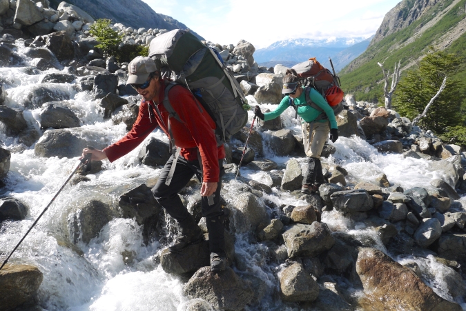 2 gap year students hiking up a stony waterway