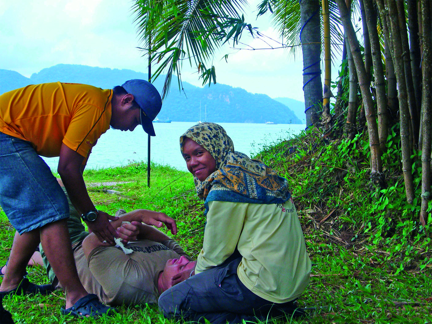 Woman wearing a head scarf and a man practice patient care on a NOLS wilderness medicine course