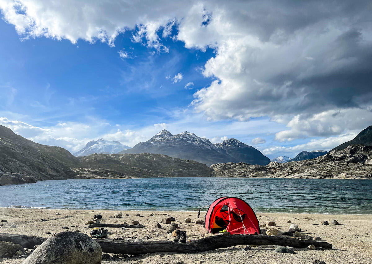 Red tent on a mountain lakeshore