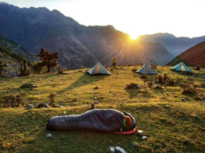 Gap year student in sleeping bag at sunrise