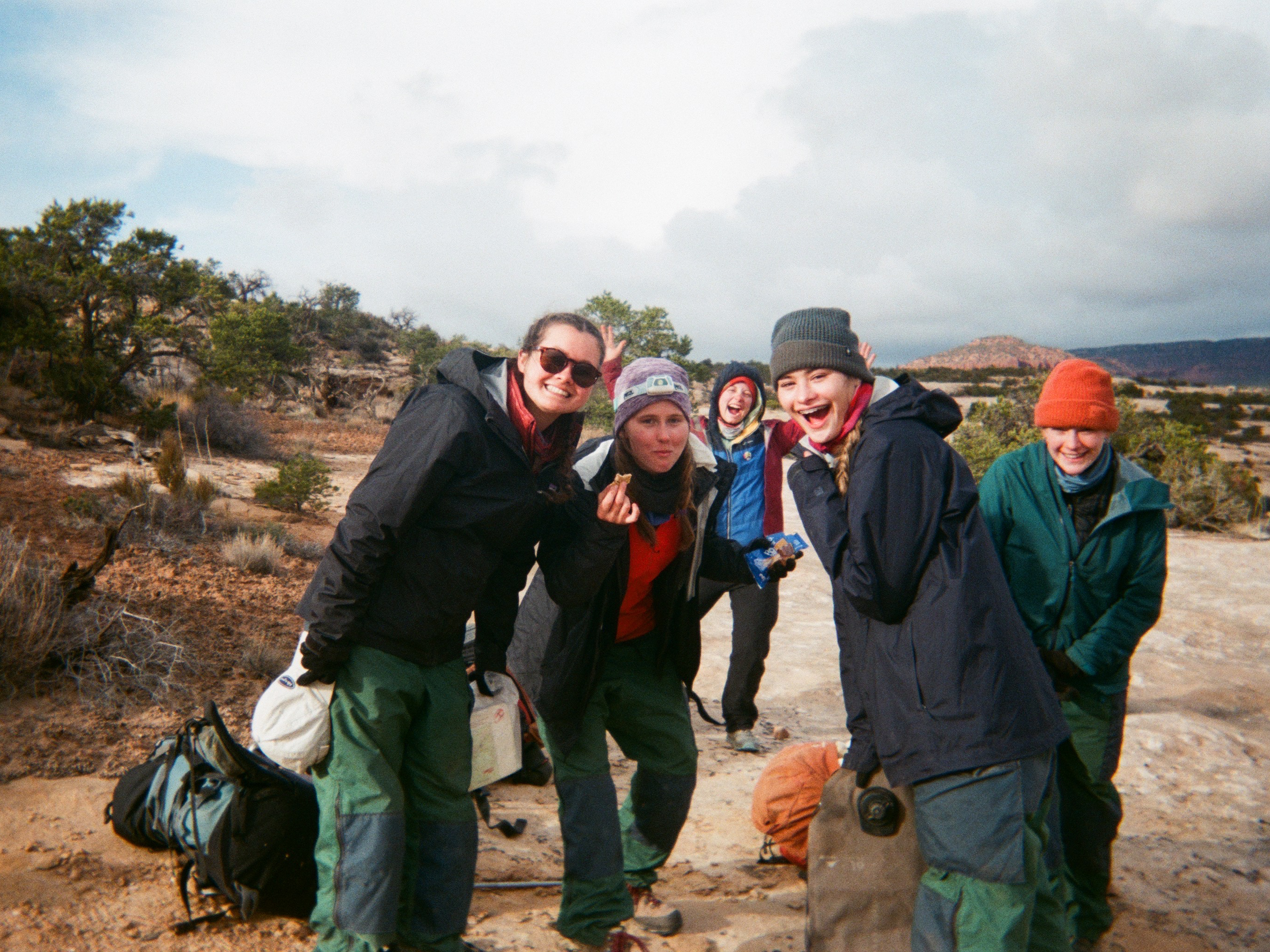 Group of students laughing while on a trail in the Utah desert.