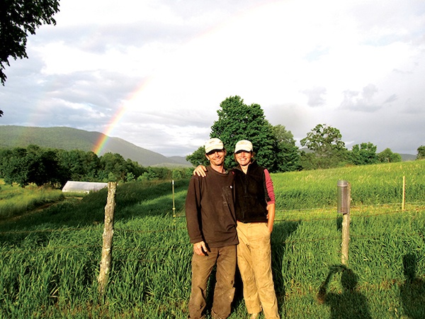 David Zuckerman and his wife stand together on their Hinesburg farm with double rainbow behind
