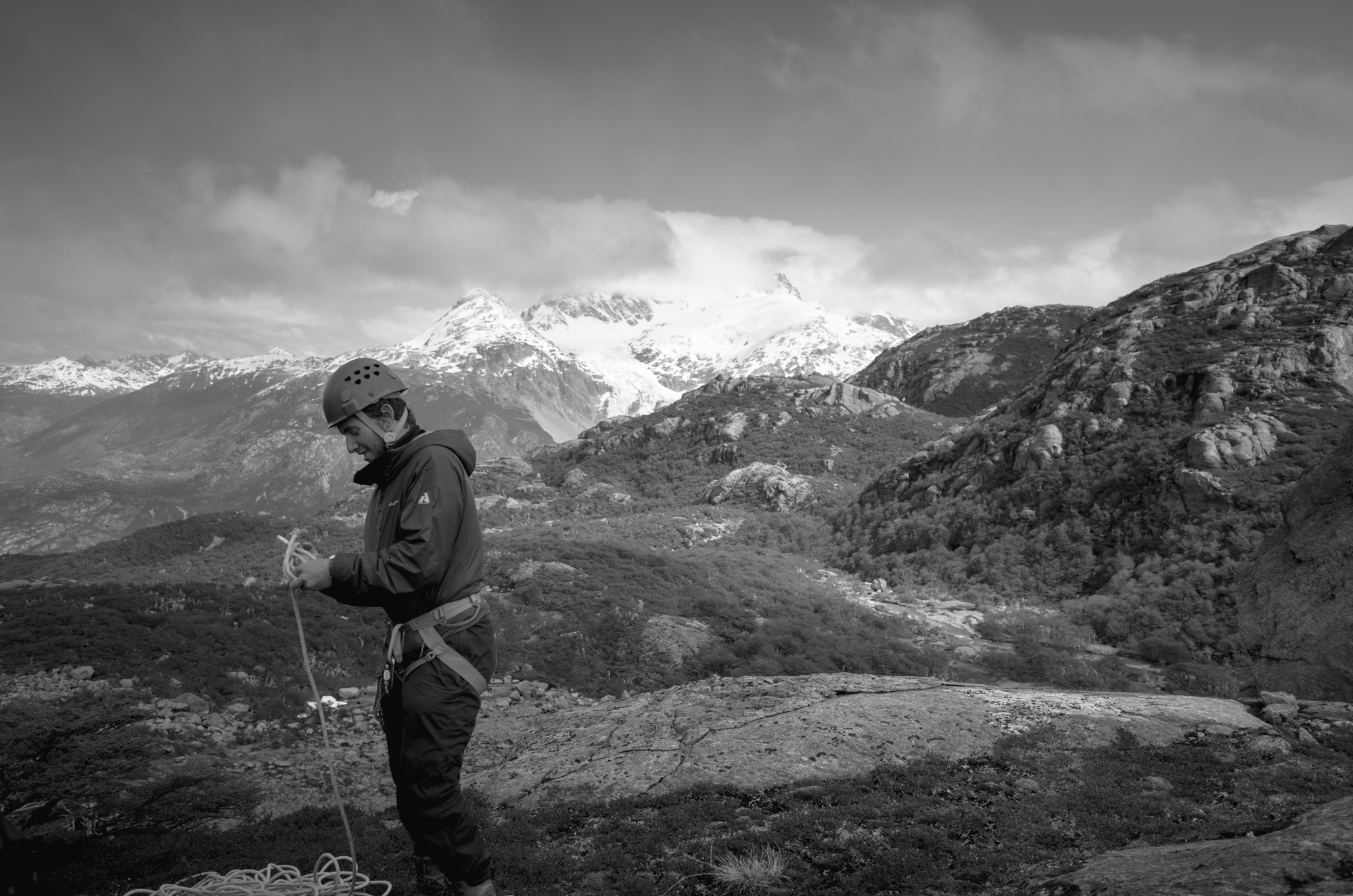 Person preparing to rappel with mountains behind