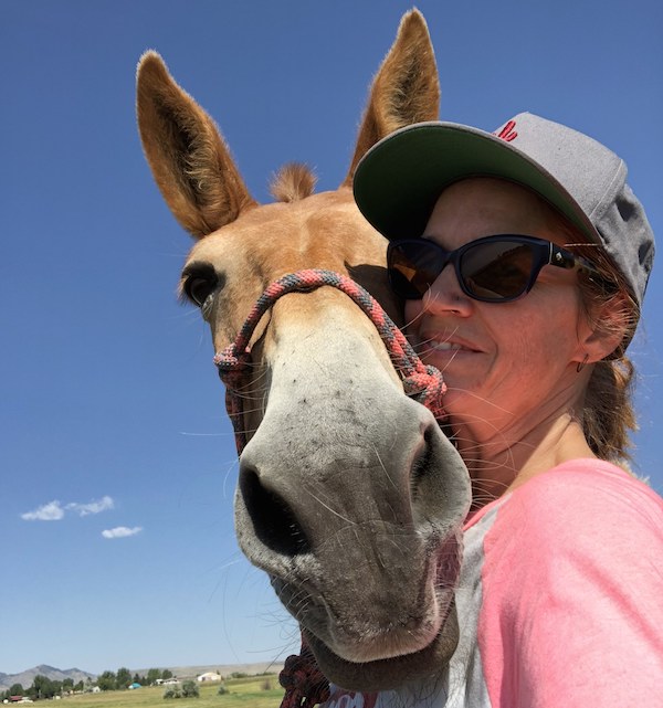 woman wearing baseball cap and sunglasses with her mule