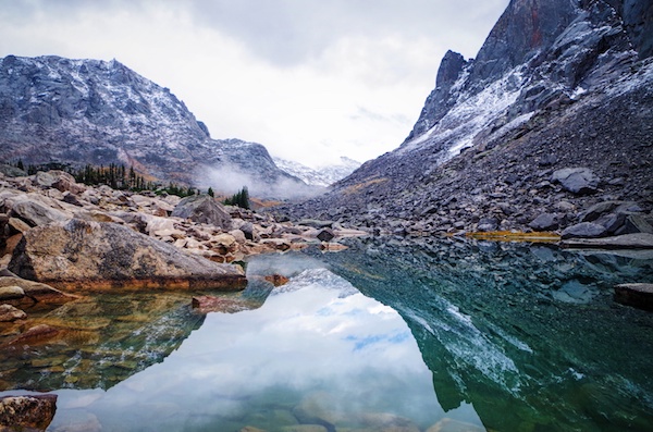 mountains and sky reflected in clear water in the Wind River Range