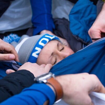 NOLS Wilderness Medicine students create a hypo wrap during a mock rescue.