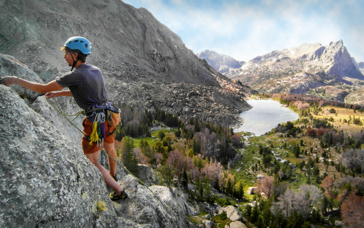 A student-led climb with a scenic rocky background.