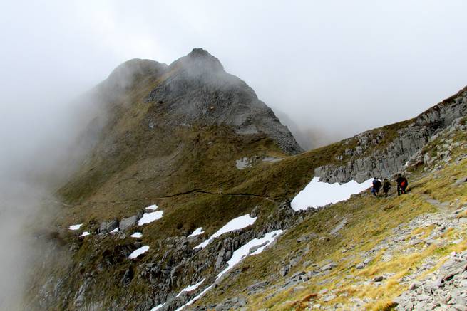 Students hiking through high misty peaks in New Zealand.