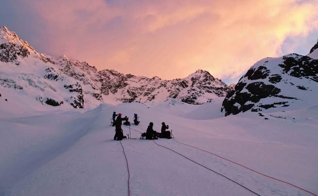 Students pause while mountaineering at to watch the sunrise.