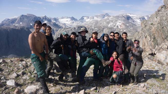 A group of students celebrates on the top of Indian Pass in the Wind River Range.