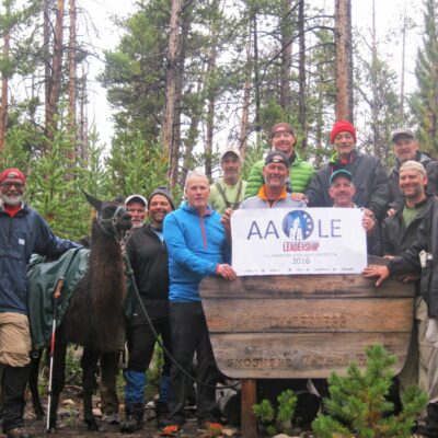 3 / 3 All American Leadership course participants smile together while on a week long backpacking, llama-supported expedition in the Wind River Mountain range.