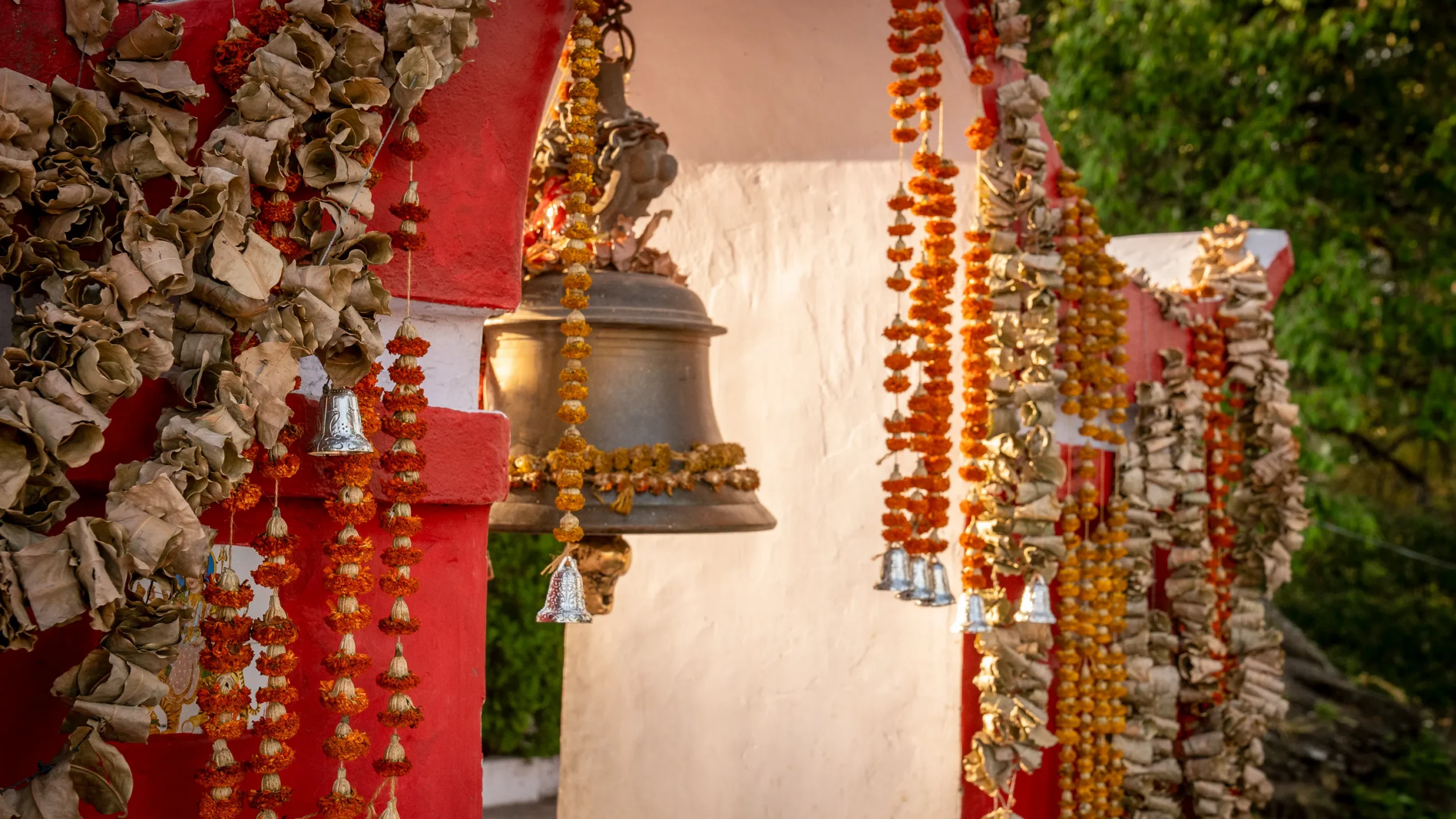 bells and red garlands hand in an archway in India