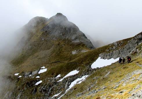 Students hiking through high misty peaks in New Zealand.