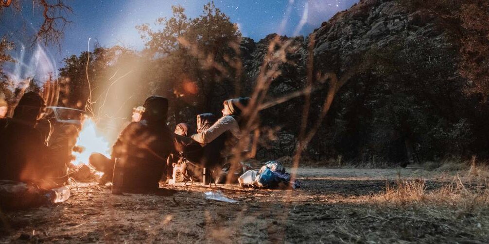 Students enjoy a campfire amidst the rugged Southwestern desert landscape.