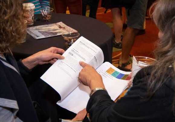 Two conference attendees look at the conference schedule.